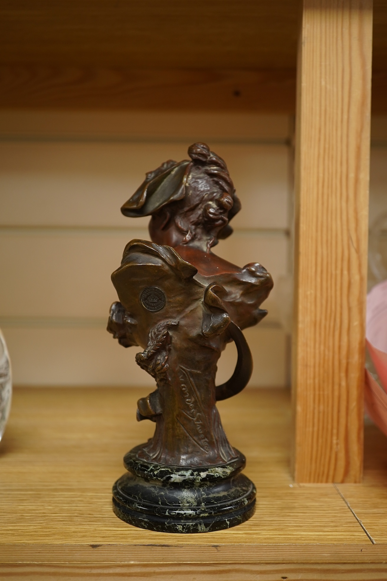 A late 19th century bronze bust of a lady in a hat with floral decoration , mounted on marble, signed, 21.5cm high.